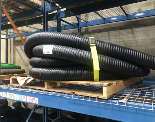 Yellow bundling strap around corrugated hose on a shelf