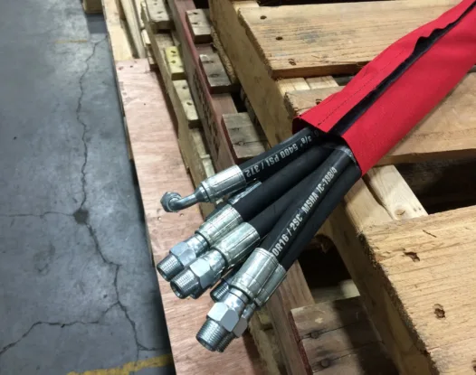 Red protective sleeve bundling hydraulic hoses