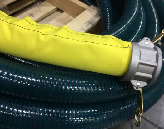 Yellow protective sleeve over a suction hose with a cam-lock coupling