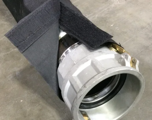 Black hook-and-loop sleeve fitted over a large coupling