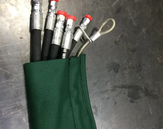 Green sleeve over a bundle of hydraulic hoses