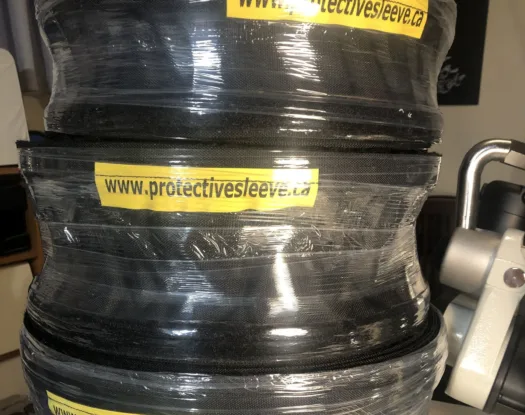 Coiled hose wrapped in protective sleeve with Protective Sleeve labels