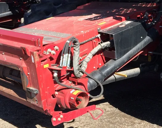 Sleeved hydraulic hoses on the header of a red Case IH harvester