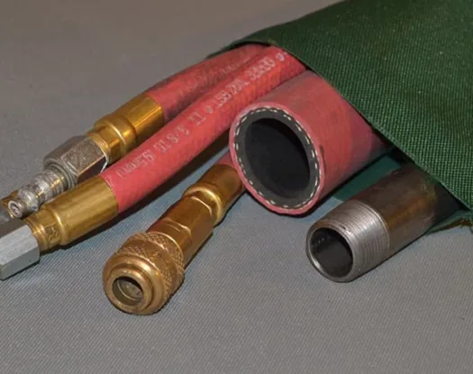 Green double-sewn sleeve over red air hoses and a pipe