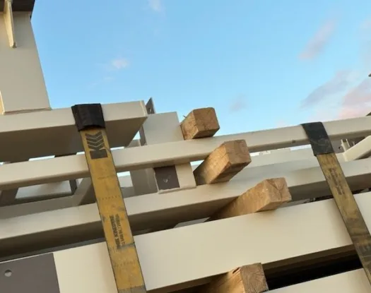 Strap savers on straps securing a load of steel