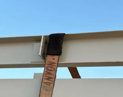 Strap saver where a load strap crosses a beam
