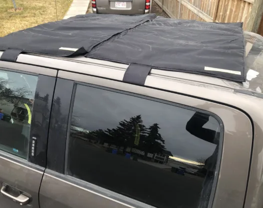 Close-up of a sunroof hail cover and its straps