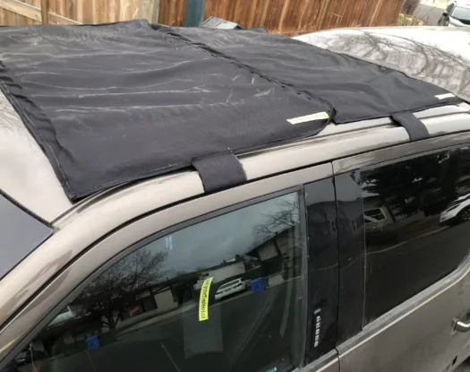 Hold-down straps securing a sunroof hail cover