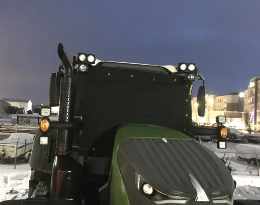 Windshield cover fitted to a tractor cab for transport