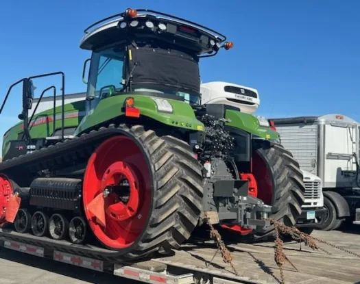 Tractor with a windshield cover on a lowboy trailer