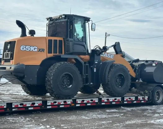 Wheel loader on a trailer with a windshield cover fitted