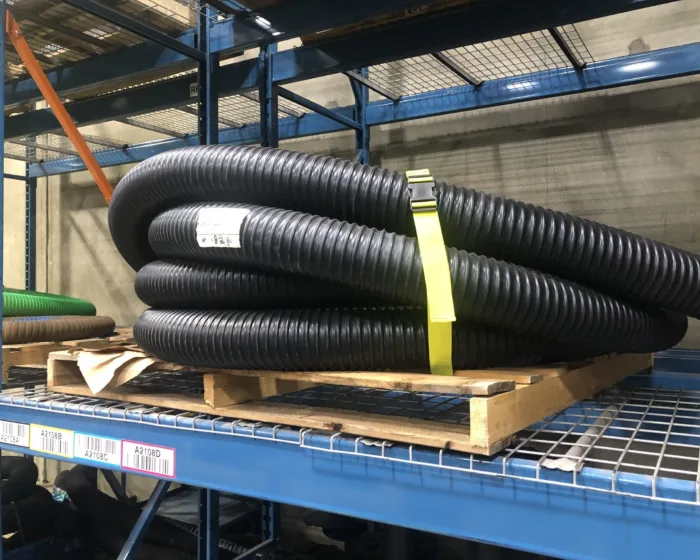 Yellow bundling strap around corrugated hose on a shelf