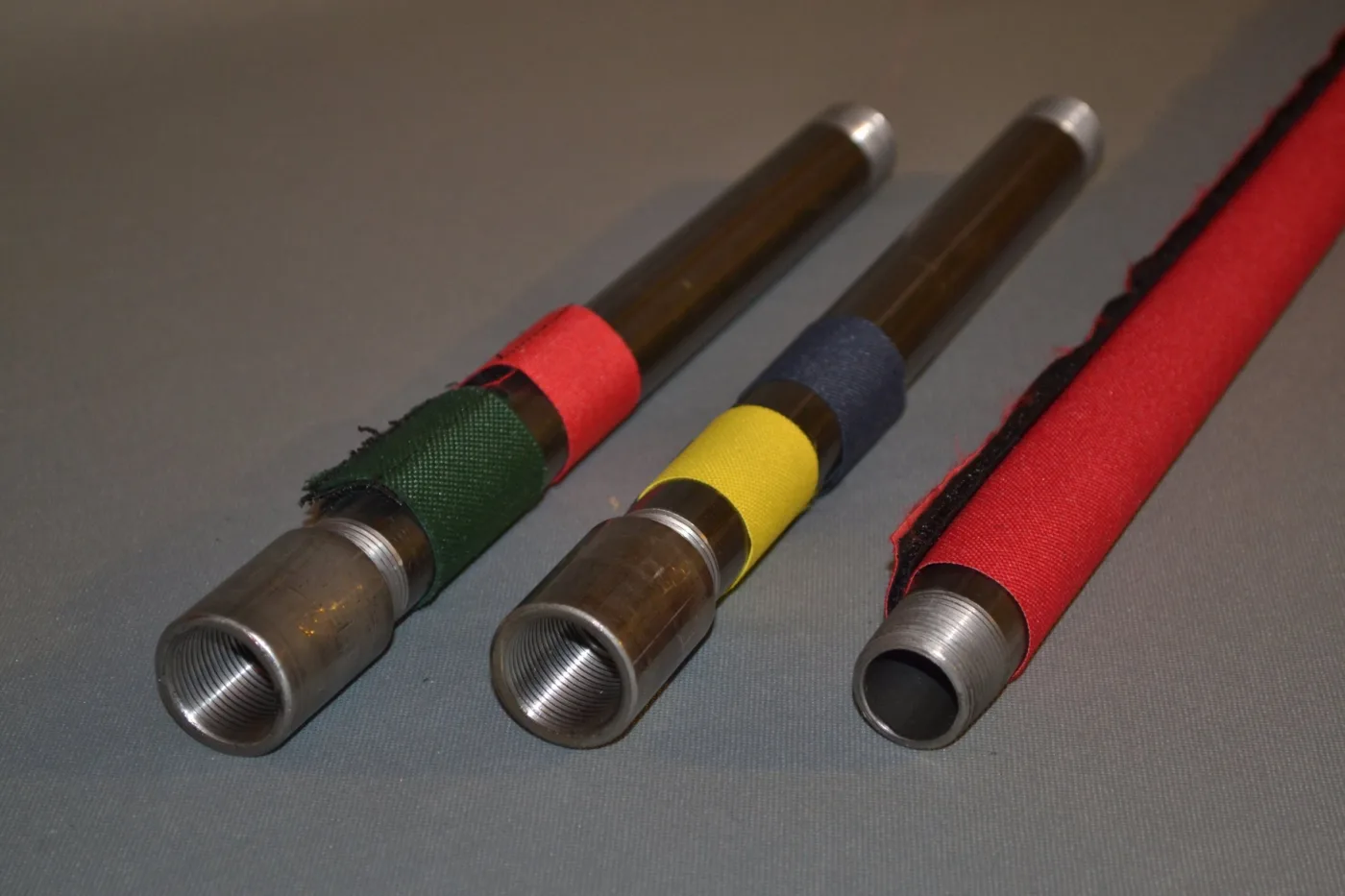 Green, yellow, blue and red markers on steel pipe