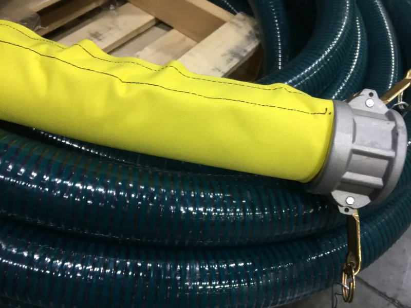 Yellow protective sleeve over a suction hose with a cam-lock coupling