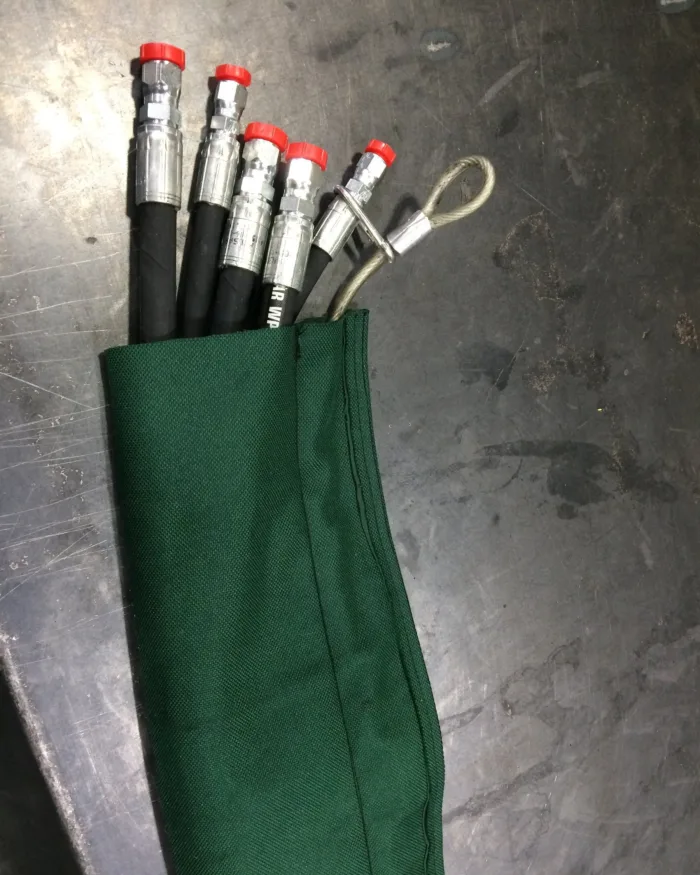 Green sleeve over a bundle of hydraulic hoses