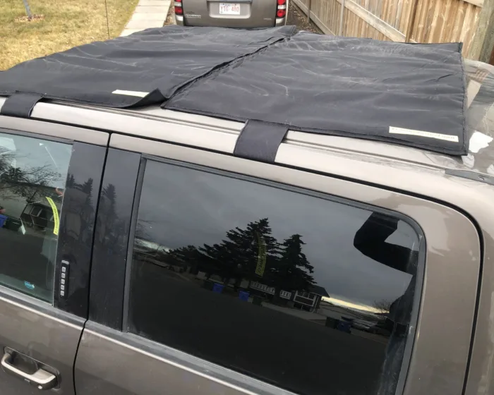 Close-up of a sunroof hail cover and its straps